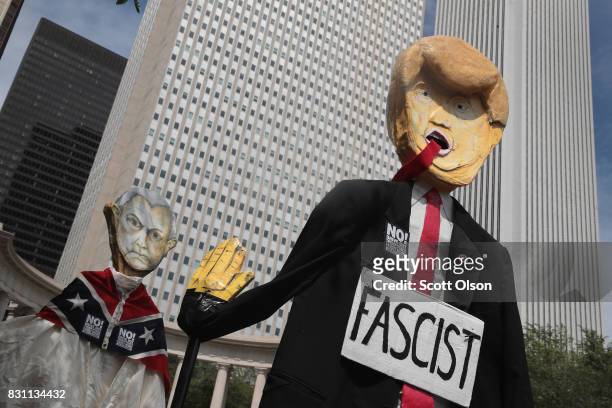 Demonstrators protesting the alt-right movement and mourning the victims of yesterdays rally in Charlottesville, Virginia carry puppets of President...