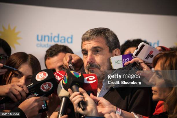 Roberto Salvarezz, candidate for the Unidad Ciudadana party, listens to members of the media at the party's headquarters during a primary election in...