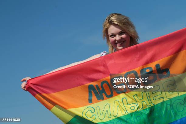 Participant hold a rainbow flag commonly known as the LGBT pride flag with the inscription 'Love is stronger than hatred' during the Gay Pride...