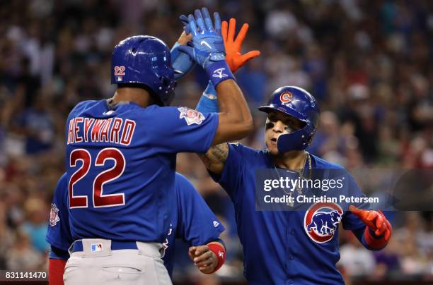 Javier Baez of the Chicago Cubs high fives Jason Heyward after hitting a three run home run against the Arizona Diamondbacks during the eighth inning...