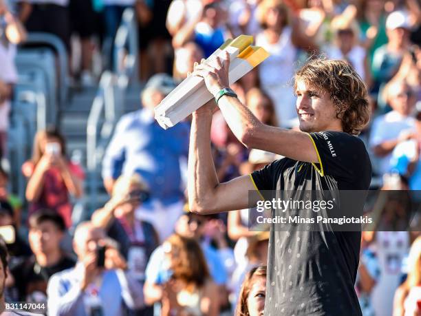 Alexander Zverev of Germany hoists the trophy up after defeating Roger Federer of Switzerland 6-3, 6-4 during day ten of the Rogers Cup presented by...