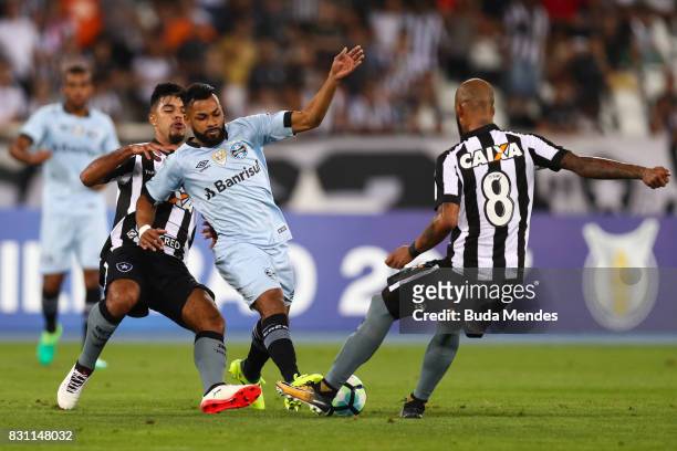Leandrinho and Bruno Silva of Botafogo struggle for the ball with Fernandinho of Gremio during a match between Botafogo and Gremio as part of...