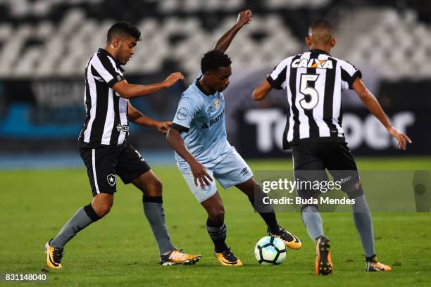 Leandrinho and Matheus Fernandes of Botafogo struggle for the ball with Lincoln of Gremio during a match between Botafogo and Gremio as part of...