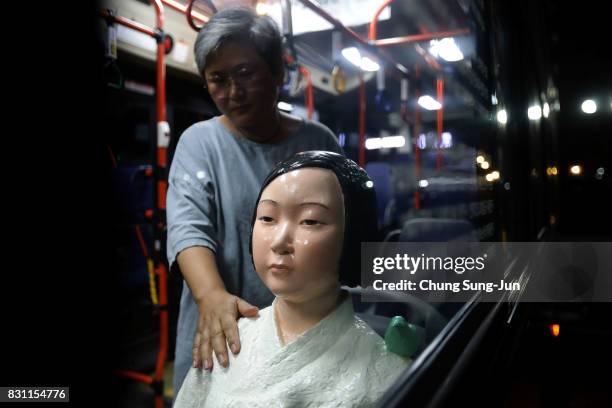 Artist Kim Seo-kyung, who have installed comfort woman statue touchs a statue in a bus ahead of the 72nd Independence Day on August 14, 2017 in...
