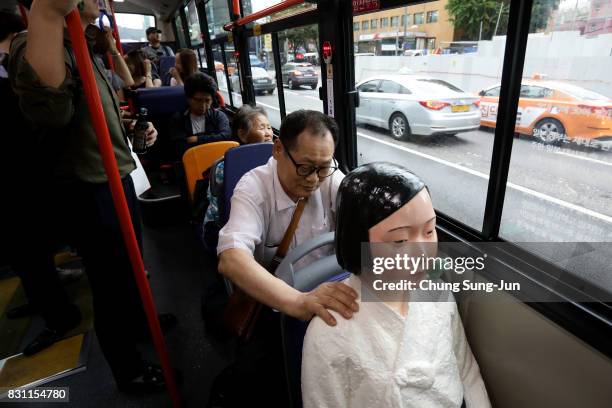 Man touches a comfort woman statue in a bus ahead of the 72nd Independence Day on August 14, 2017 in Seoul, South Korea. The statue was originally...