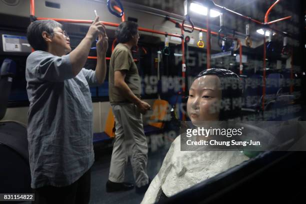 Artist Kim Eun-sung and Kim Seo-kyung, who have installed comfort woman statue look around in a bus ahead of the 72nd Independence Day on August 14,...