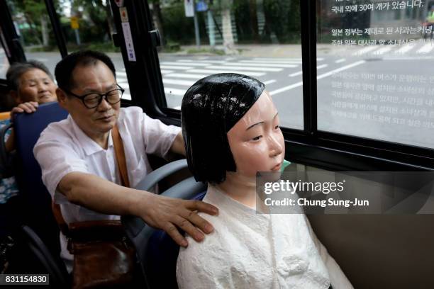 Man touches a comfort woman statue in a bus ahead of the 72nd Independence Day on August 14, 2017 in Seoul, South Korea. The statue was originally...