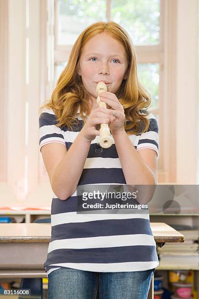 girl playing recorder in classroom - blockflöte stock-fotos und bilder