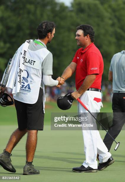 Patrick Reed of the United States shakes hands with Graham DeLaet of Canada's caddie Julien Trudeau during the final round of the 2017 PGA...