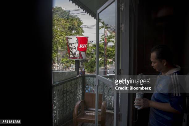 Worker paints near signage for a Yum! Brands Inc. KFC restaurant in Bangkok, Thailand, on Saturday, Aug. 12, 2017. Thai Beverage, the spirits giant...