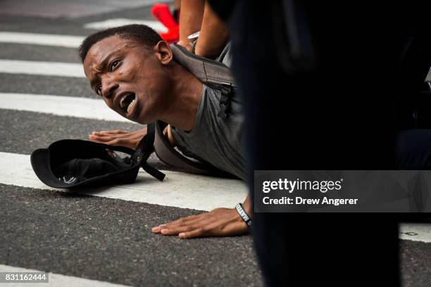 Protestor, who was marching on 5th Avenue against white supremacy and racism, is held on the ground while being arrested by New York City Police...