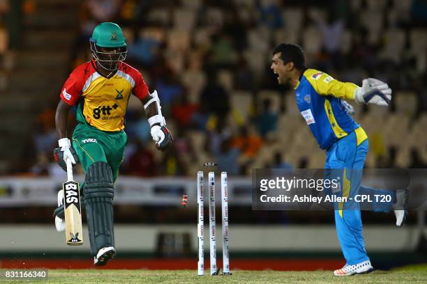In this handout image provided by CPL T20, Jason Mohammed of the Guyana Amazon Warriors makes his ground as St Lucia Stars wicket keeper Kamran Akmal...