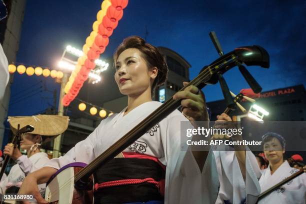 This photo taken on August 13, 2017 shows performers playing the shamisen, a three-stringed instrument, during the Awa Odori festival in Tokushima....