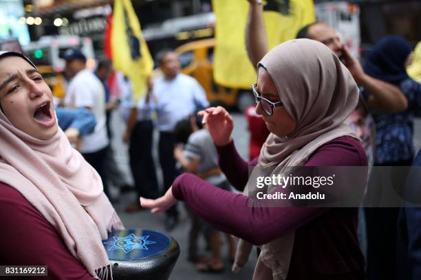 Girl plays drums during a protest marking the fourth anniversary of Rabaa El Adaweya massacre in Times Square of Manhattan borough of New York,...