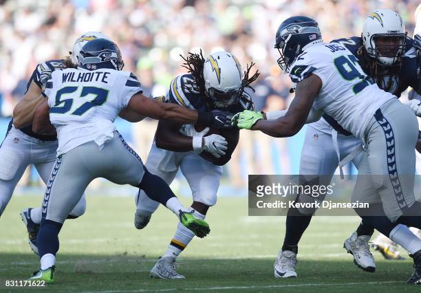 Running back Melvin Gordon of the Los Angeles Chargers rushes as he is tackled by Mike Morgan and Nazair Jones of the Seattle Seahawks during a pre...