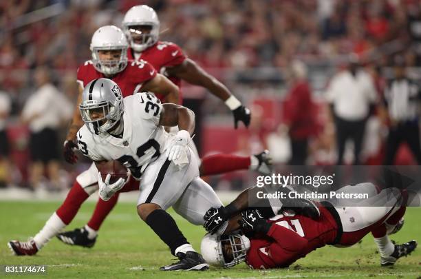 Running back DeAndre Washington of the Oakland Raiders is tackled by cornerback Justin Bethel of the Arizona Cardinals during the NFL game at the...