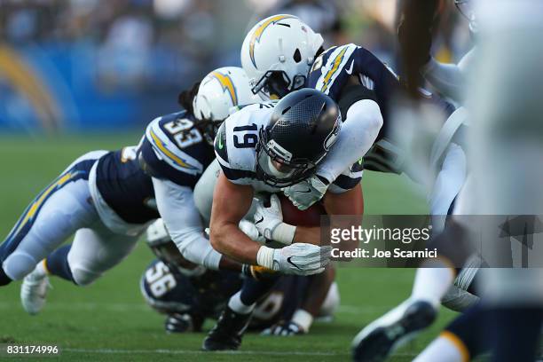 Tanner McEvoy of the Seattle Seahawks is tackled by Tre Boston of the Los Angeles Chargers in the second quarter at StubHub Center on August 13, 2017...