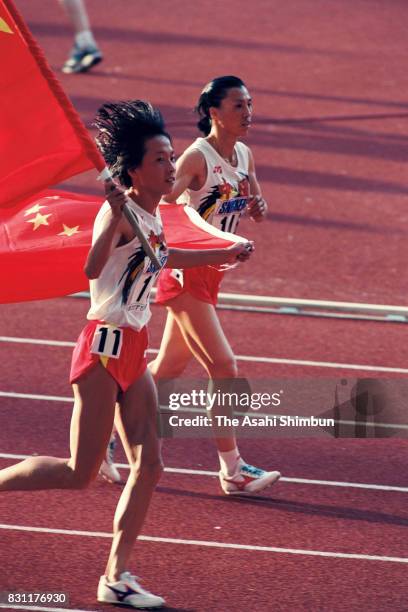 Wang Junxia of China and Zhong Huandi of China celebrate winning the gold and silver medals respectively in the Wmen's 10,000m during the 4th World...