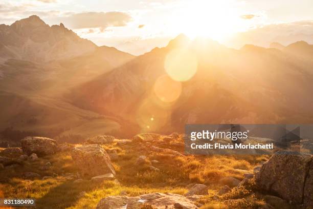 sun over dolomites mountains - protuberanz stock-fotos und bilder