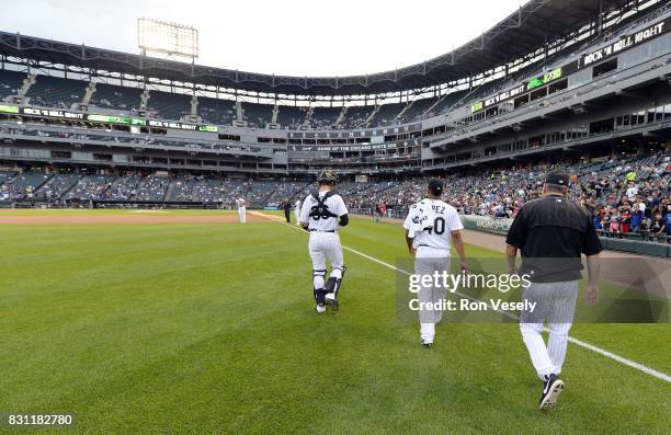 Reynaldo Lopez, pitching coach Don Cooper and catcher Kevan Smith of the Chicago White Sox walk toward the dugout prior to the game against the...