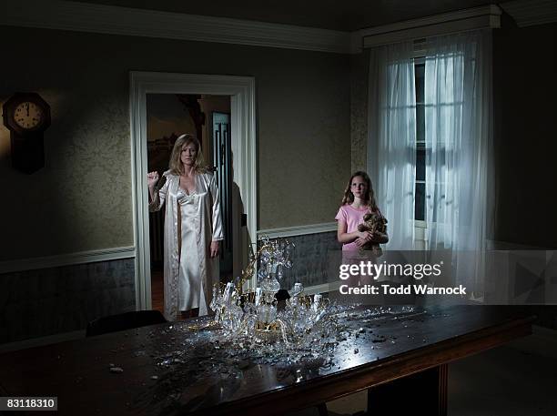 mother and daughter looking at broken chandelier - girl looking down stock pictures, royalty-free photos & images