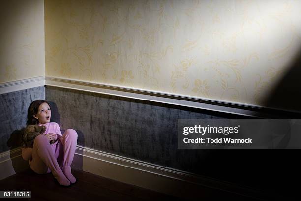 frightened girl in pajamas cowering in corner - hidden danger stock pictures, royalty-free photos & images