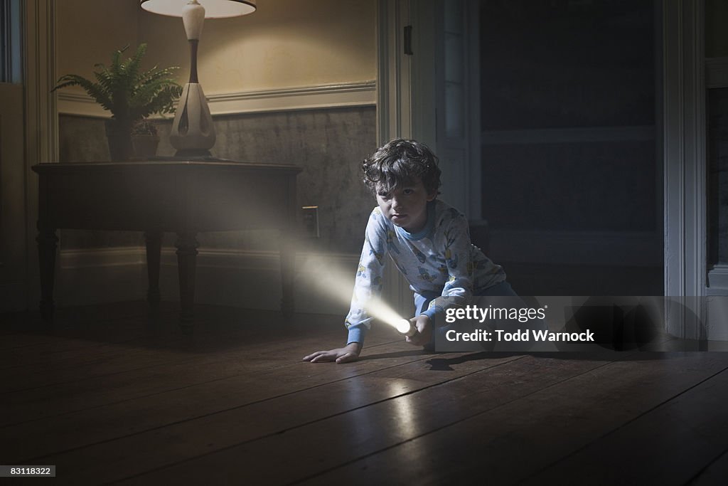 Boy searching with flashlight