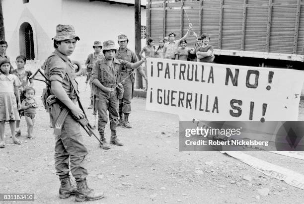 Guatemalan Army soldiers display a captured Ejercito Guerrillero de los Pobres banner, Huehuetenango, Guatemala, mid September 1982. The soldiers...