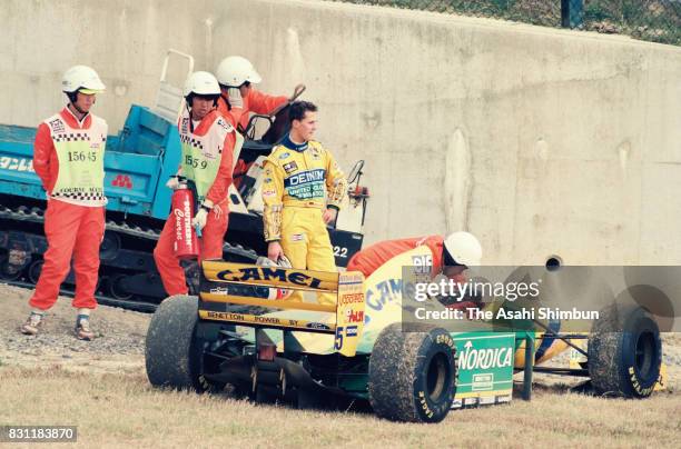 Michael Schumacher of Germany and Benetton-Ford stands by his machine after retiring during the Formula One Japanese Grand Prix at Suzuka Circuit on...