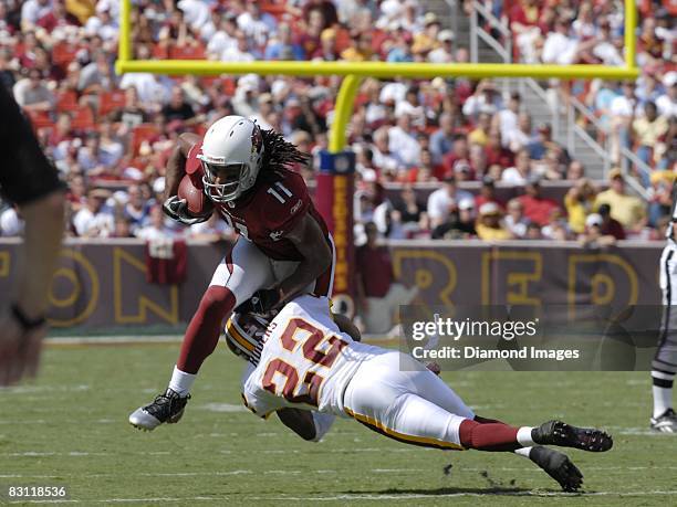 Wide receiver Larry Fitzgerald of the Arizona Cardinals tries to shake the tackle of defensive back Carlos Rogers of the Washington Redskins during a...