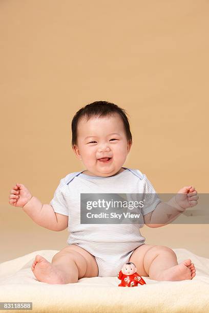 baby (6-9 months) with toy, smiling - 6 11 maanden stockfoto's en -beelden