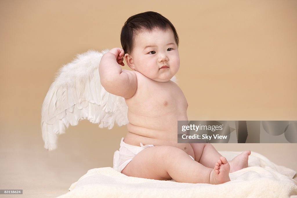 Baby (6-9 months) wearing angel wings