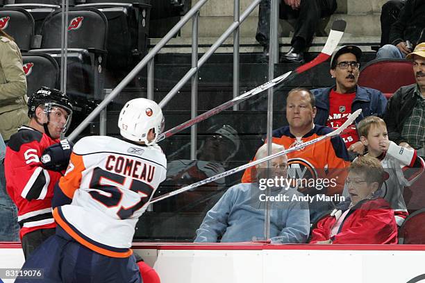 Fans react as right wing Blake Comeau of the New York Islanders and defenseman Colin White of the New Jersey Devils collide during the third period...