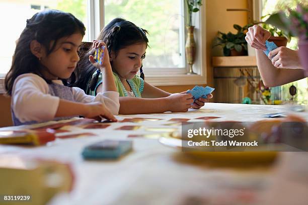 schwestern spielen - kartenspiel tisch stock-fotos und bilder
