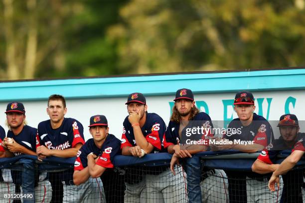 Members of the Bourne Braves look on from their dugout during game one of the Cape Cod League Championship Series against the Brewster Whitecaps at...