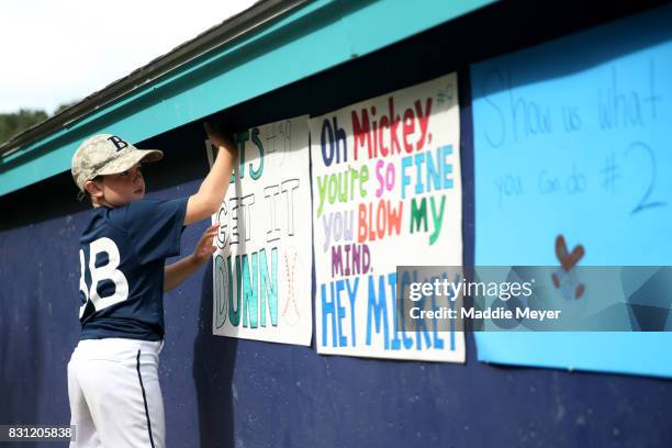 Ethan Carey of Harwich, MA, hangs signs in support of the Brewster Whitecaps before game one of the Cape Cod League Championship Series at Stony...