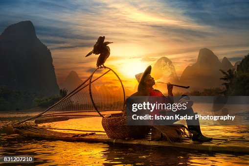 Cormorant Fisherman Smoking Pipe at Sunset, Yangshuo China Cormorant Fisherman Smoking Pipe at Sunset, Yangshuo China