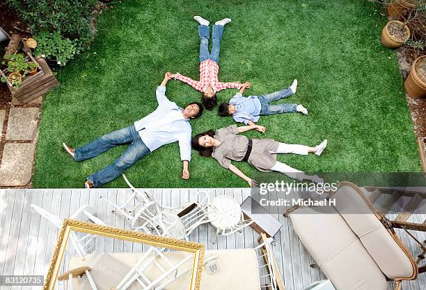 family lie down on lawn in garden - boy lying down stock pictures, royalty-free photos & images