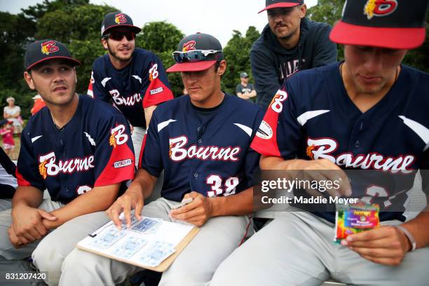 Members of the Bounre Braves play the card game President during game one of the Cape Cod League Championship Series against the Brewster Whitecaps...