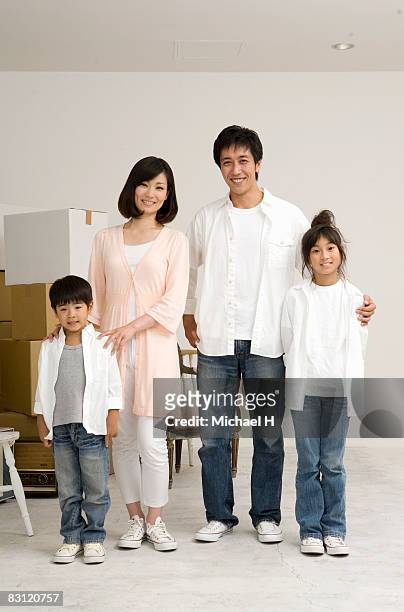 family's portrait,the time of move - family of four in front of house stock-fotos und bilder