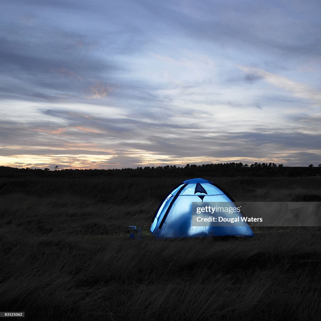 Silhouette of couple kissing in tent.