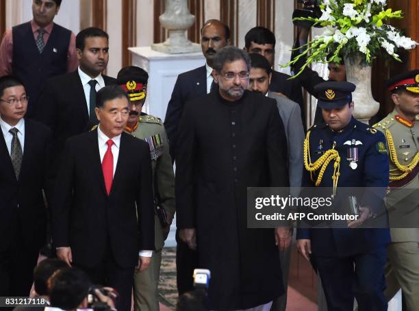 Chinese Vice Premier Wang Yang is flanked by Pakistan's Interim Prime Minister Shahid Khaqan Abbasi as they arrive to attend a flag hoist ceremony to...