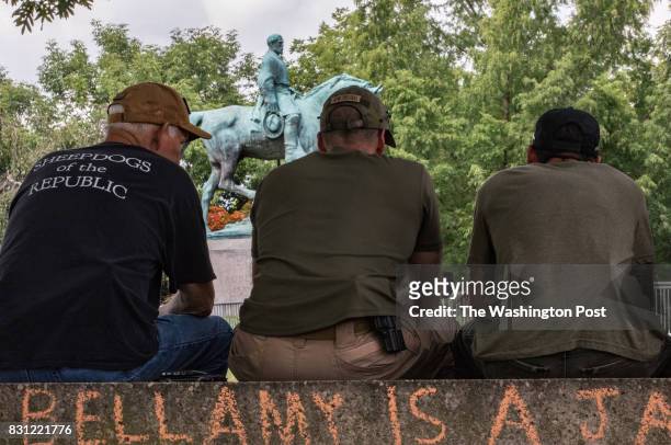 Members of a group called the Constitutionalists, a militia that has come to Charlottesville to defend the constitution and keep the peace, sit in...