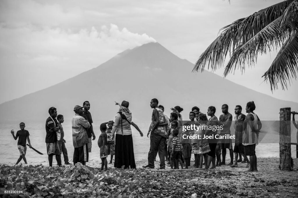 American woman and local villagers near Manam Island volcano