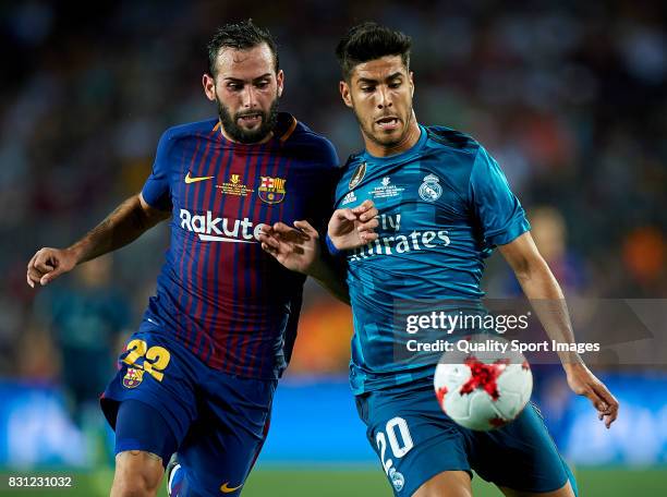 Aleix Vidal of Barcelona competes for the ball with Marco Asensio of Real Madrid during the Supercopa de Espana Supercopa Final 1st Leg match between...