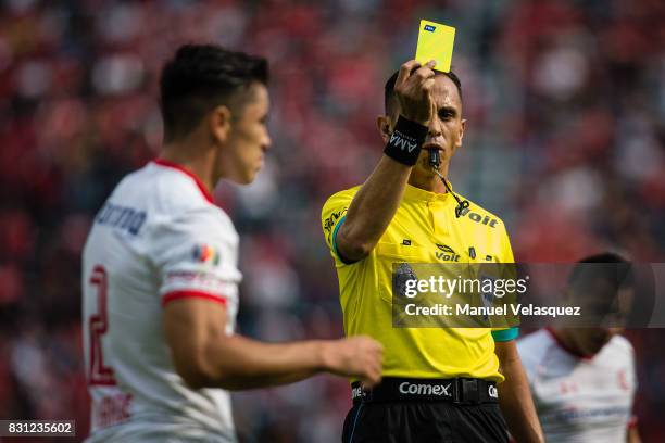 Luis Enrique Santander , central referee shows a yellow card to Efrain Velarde of Toluca during the 4th round match between Cruz Azul and Chivas as...