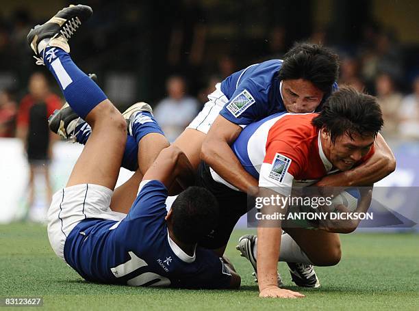 South Korea's Han Kun Kyu is tackled by Taiwan's players during their match at the IRB Rugby world cup Sevens 2009 Asian qualifier match in Hong Kong...