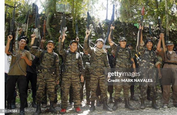 Armed separatist Muslim guerrillas of the Moro Islamic Liberation Front raise their rifles after they declared red alert status around Camp...