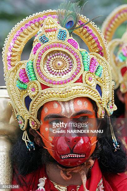 An Indian Hindu devotee, dressed as the monkey god Hanuman, participates in a religious procession to celebrate the festival of Dussehra at The...