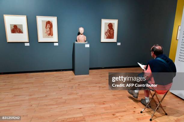 Visitor draws in front of artworks by French artist and painter Georges Dorignac during the exhibition "Georges Dorignac, le trait sculpte" at the...